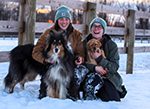 Farm dogs Huxley the collie and Joni the Labrador are sitting with Farm staffers Becky and Jacobi